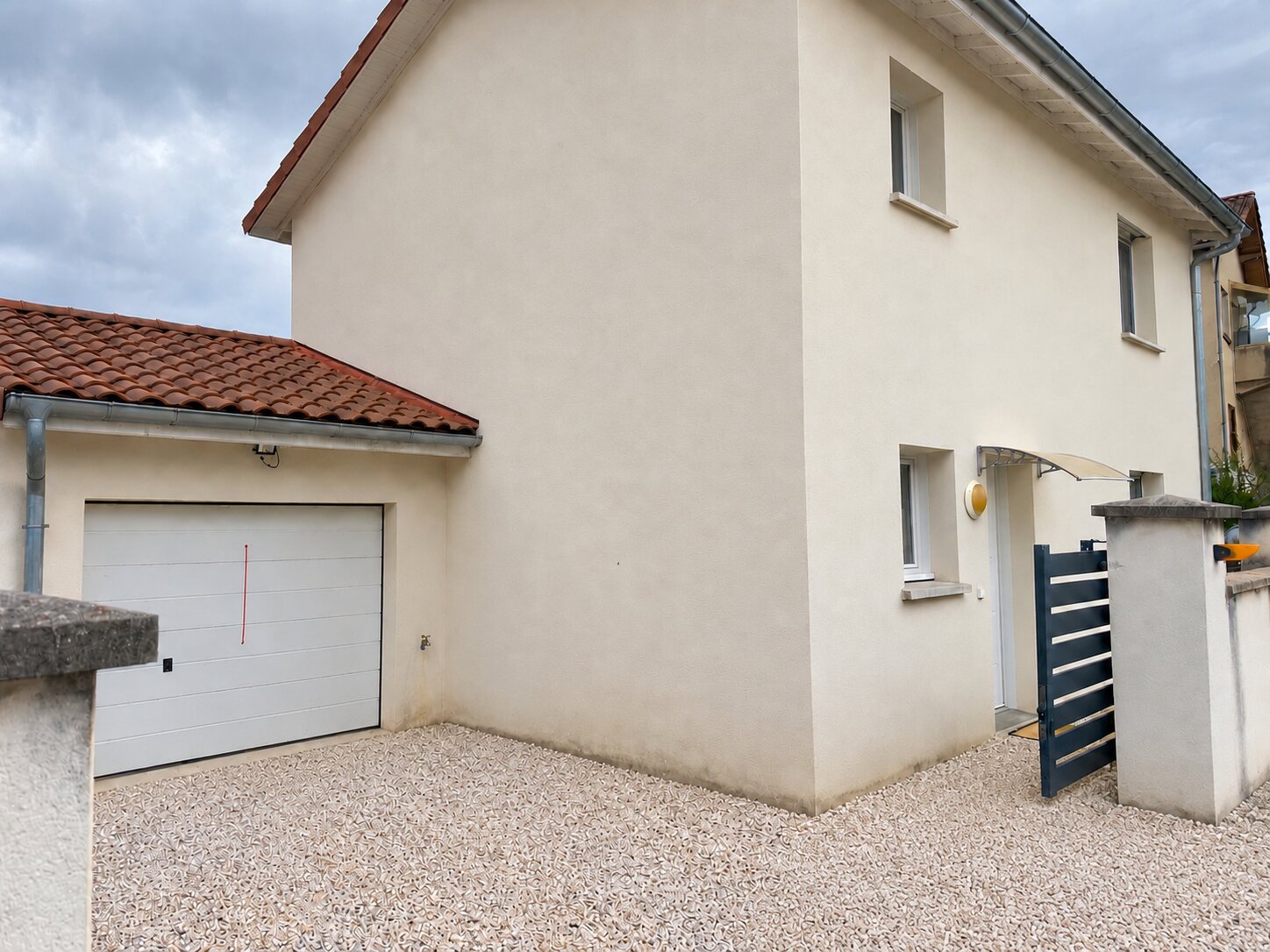 Façade de la maison et garage à porte motorisée